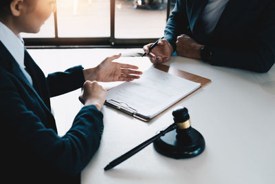 Midsection of lawyer shaking hands