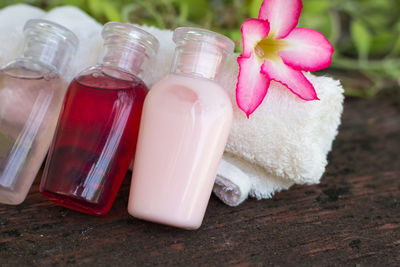 High angle view of beauty products with towel and flower on table