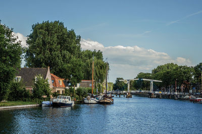 River amidst trees and buildings against sky