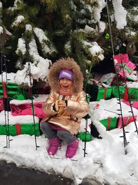 Girl standing by tree in snow