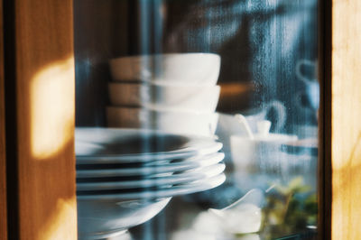 Close-up of crockery in cabinet at home