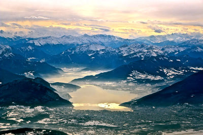 Scenic view of snowcapped mountains against sky during sunset