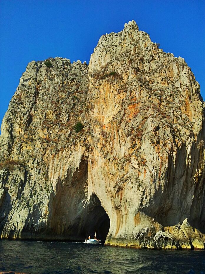 water, rock formation, clear sky, sea, blue, rock - object, scenics, waterfront, tranquil scene, cliff, tranquility, beauty in nature, nature, rocky mountains, geology, rock, mountain, physical geography, eroded, idyllic