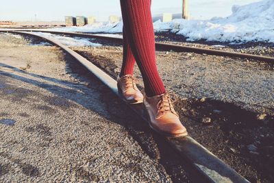 Low section of person walking on railroad track