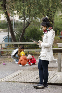 Woman at playground using digital tablet