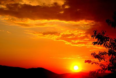 Silhouette landscape against dramatic sky during sunset