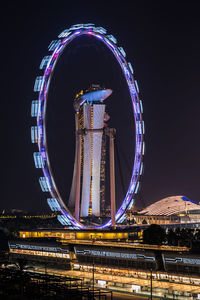 Illuminated bridge over river at night