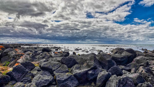 Rocks on beach against sky