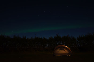 Tent on field against sky at night