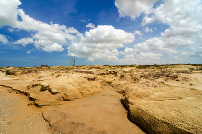 Arid landscape against cloudy sky