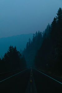 Road amidst trees against sky