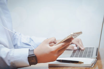 Midsection of man using mobile phone