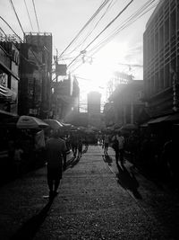 Group of people walking on city street amidst buildings