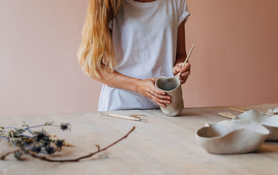 Midsection of woman holding ice cream at home