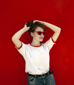 Portrait of boy wearing sunglasses against red wall