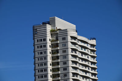 Low angle view of modern buildings against clear blue sky