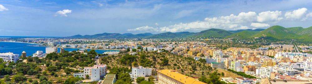 Panoramic shot of cityscape by sea against sky