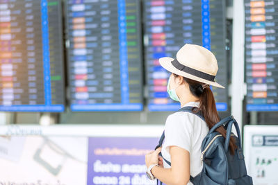 Woman with mask looking away in airport outdoors