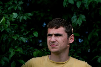 Young man hiding in a bush. defocus portrait young man on a nature background. sad young man. 20s 