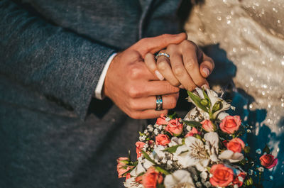 Midsection of man holding flower bouquet