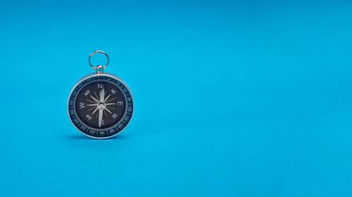 Low angle view of clock against blue background