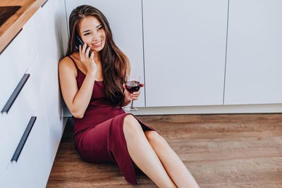 Young woman smiling while sitting on floor