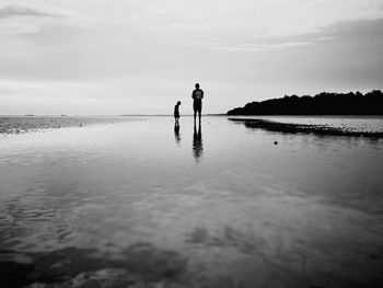 Silhouette man standing on beach against sky