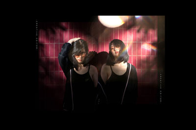 Portrait of a young woman against black background