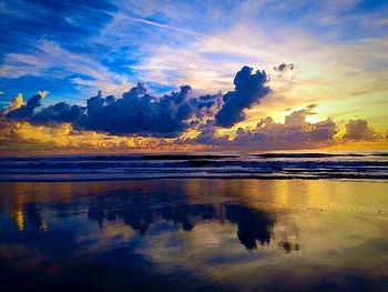 Reflection of clouds in sea at sunset