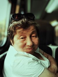 Close-up portrait of senior woman making face while traveling in train