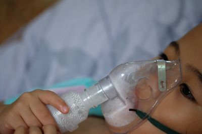 Close-up of girl wearing oxygen mask