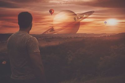 Rear view of man looking at sunset