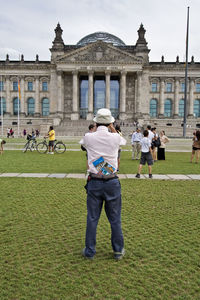Rear view of people outside the reichstag against sky