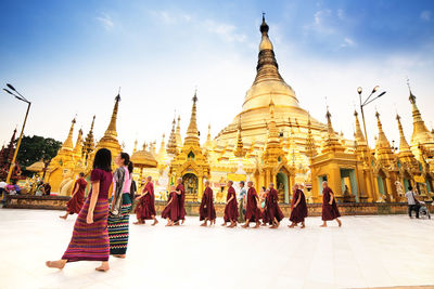 Group of people outside temple against building