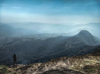 Rear view of man looking at mountain range