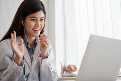 Smiling young woman using mobile phone