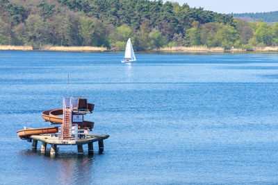 Sailboat in sea against trees