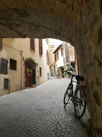 Bicycle parked on street by wall in tunnel