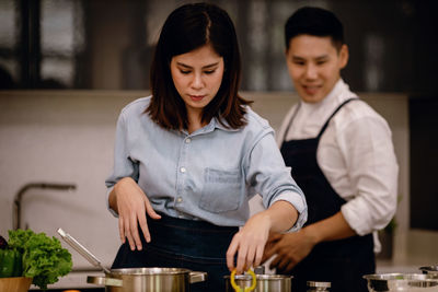 Man looking at woman preparing food