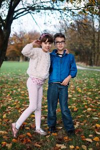 Full length portrait of happy young woman standing in park