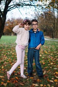 Full length portrait of siblings standing in park