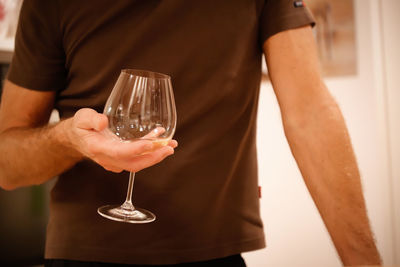 Midsection of man holding wine glass