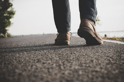 Low section of man standing on road