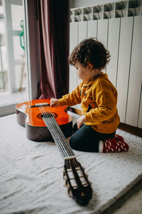 Child playing guitar at home