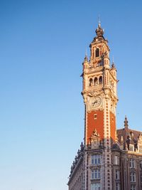 Low angle view of clock tower against blue sky