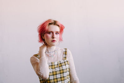 Young woman standing against wall