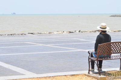 Rear view of man on beach against sky