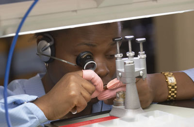 Female watch maker working in industry