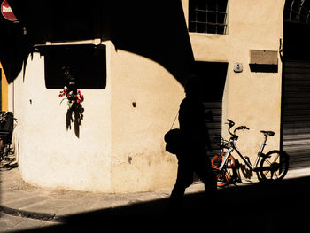 Shadow of man with bicycle standing on street