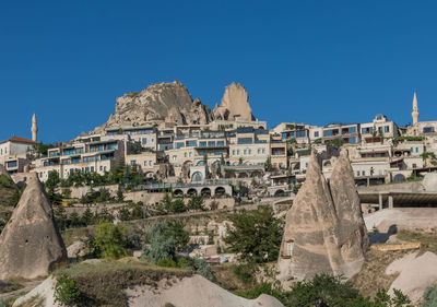 Buildings in city against clear blue sky